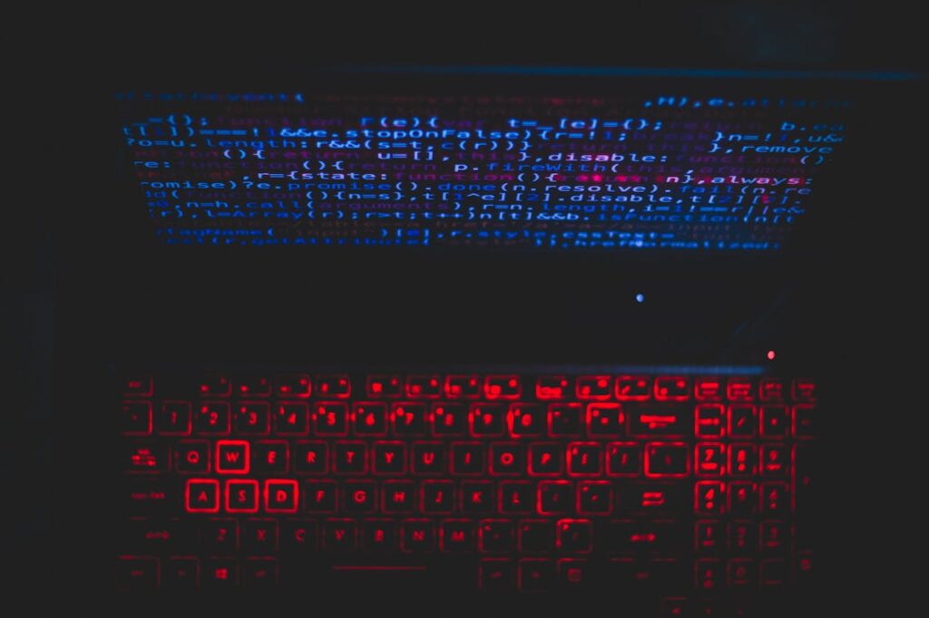 pexels photo 1933900 Dark-themed laptop setup with a red glowing keyboard and code on screen, ideal for tech enthusiasts.